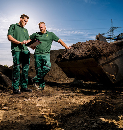 Zwei Landschaftsgärtner auf der Baustelle, die sich einen Plan angucken und besprechen